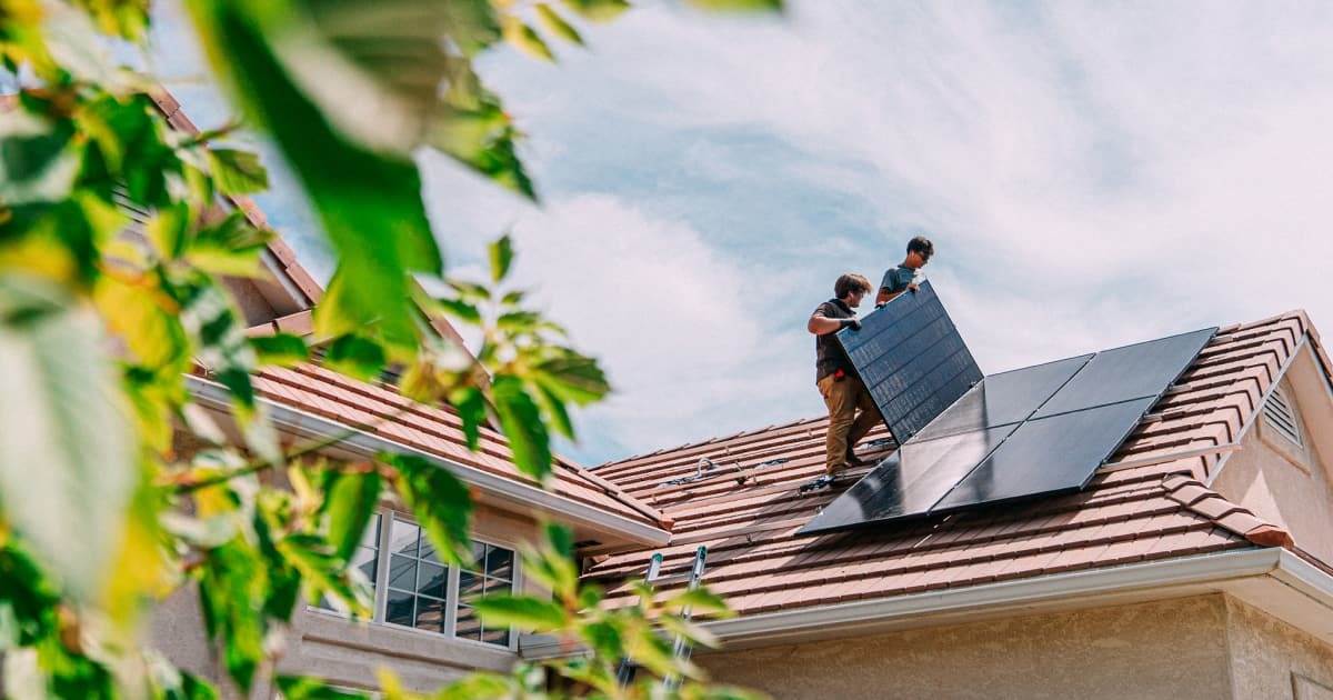 Workers installing solar panels on rooftop